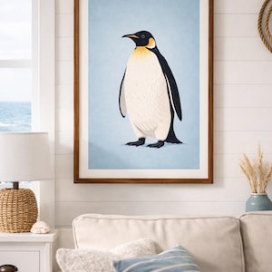 Puede incluir: Una impresi&oacute;n art&iacute;stica enmarcada con una ilustraci&oacute;n de un ping&uuml;ino. El ping&uuml;ino tiene la cabeza y la espalda negras, el vientre blanco y detalles amarillos. El fondo es azul claro y el marco es marr&oacute;n. La obra se exhibe en un sal&oacute;n.