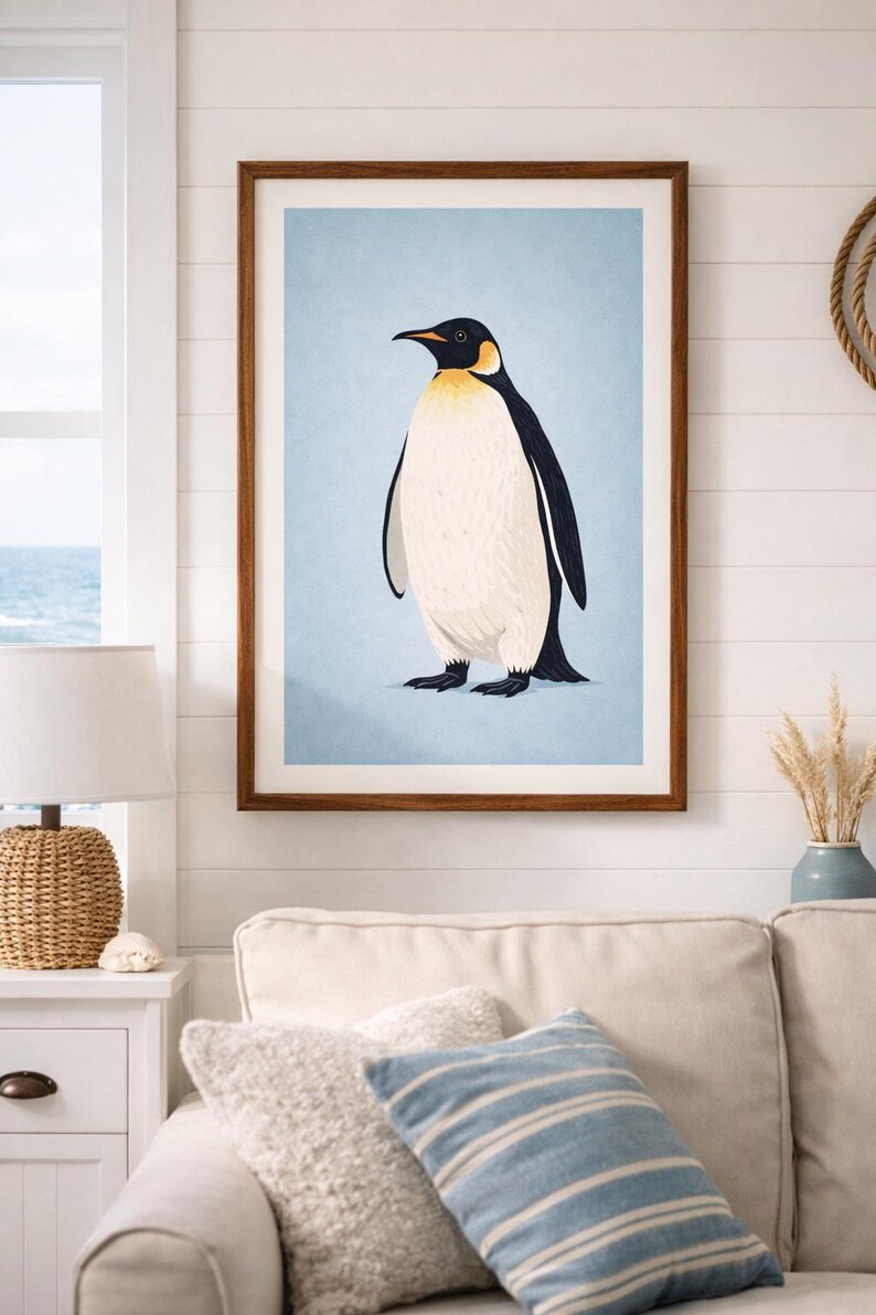 Puede incluir: Una impresi&oacute;n art&iacute;stica enmarcada con una ilustraci&oacute;n de un ping&uuml;ino. El ping&uuml;ino tiene la cabeza y la espalda negras, el vientre blanco y detalles amarillos. El fondo es azul claro y el marco es marr&oacute;n. La obra se exhibe en un sal&oacute;n.