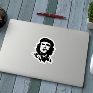 May include: Black and white silhouette sticker of a man with a beard and a beret. The man is looking to the right.