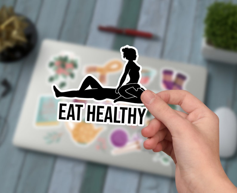 Może przedstawiać: Czarno-biała naklejka z sylwetką dw&oacute;ch os&oacute;b w sugestywnej pozie. Tekst "EAT HEALTHY" jest nadrukowany pod postaciami.