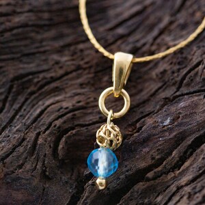 Topacio azul y oro. Colgante pequeño de diseño. Colgante de topacio único. Montura de plata de ley. Cubierto de oro de 14 quilates. Colgante hecho a mano.