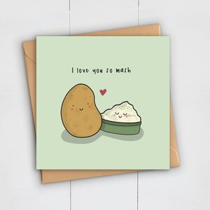 May include: A square greeting card with a light green background and a brown envelope. The card features a cartoon potato and mashed potatoes with the text "I love you so mash" and a red heart.