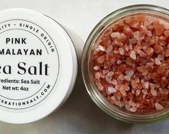 May include: A glass jar filled with coarse pink Himalayan sea salt, accompanied by a white lid featuring the text: HIGH QUALITY - SINGLE ORIGIN, PINK HIMALAYAN, Sea Salt, Ingredients: Sea Salt, Net wt: 4oz, WWW.LIBERATIONSALT.COM.