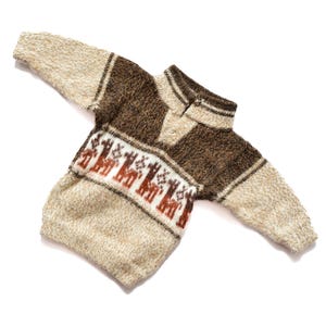 May include: A brown and beige knitted jumper with a geometric pattern of llamas. The jumper has a high neck and long sleeves.