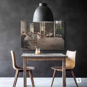 May include: A black pendant light hangs over a wooden table with two chairs. A framed print of a ballet scene hangs on the wall behind the table.