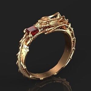 Op de afbeelding: Een gouden drakenring met een rode edelsteen. De kop van de draak bevindt zich bovenop de ring en de staart wikkelt zich om de band.