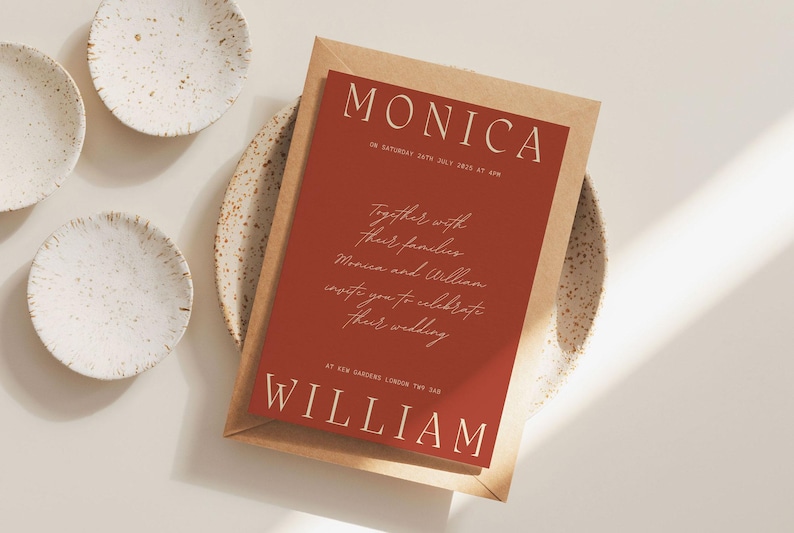 May include: A red wedding invitation with white text. The invitation reads "Monica and William together with their families invite you to celebrate their wedding at New Garden, London, TW1 2AA."