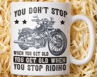 May include: White ceramic mug with a black and white illustration of a motorcycle and the text "You don't stop when you get old, you get old when you stop riding."