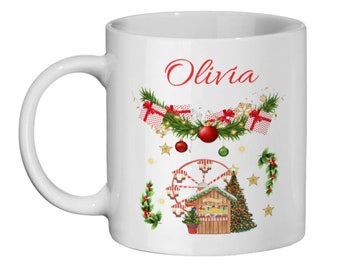 Könnte beinhalten: Weiße Keramik-Tasse mit weihnachtlichem Design. Die Tasse zeigt den Namen "Olivia" in roter Schrift, eine festliche Girlande, Geschenkboxen, Ornamente, ein Riesenrad und einen Weihnachtsbaum. Das Design umfasst goldene Sterne und grüne Akzente.