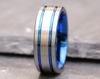 May include: A silver ring with two blue stripes around the band.
