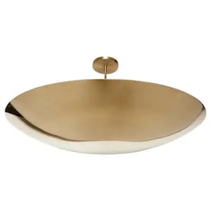 May include: A large, round, brass pendant light fixture with a smooth, slightly curved surface.