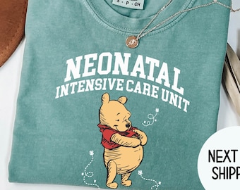 May include: Light green t-shirt with a white graphic of Winnie the Pooh and the text "Neonatal Intensive Care Unit".