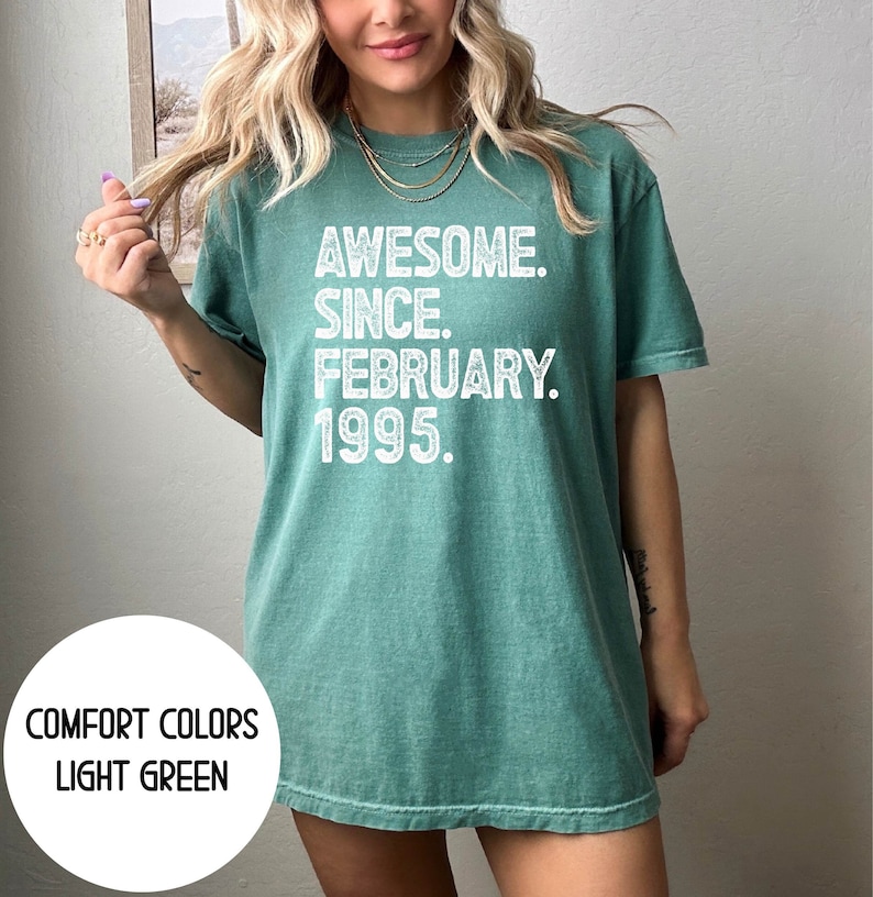 May include: Light green t-shirt with the text "AWESOME. SINCE. FEBRUARY. 1995." in white. The shirt is a Comfort Colors brand and is light green.
