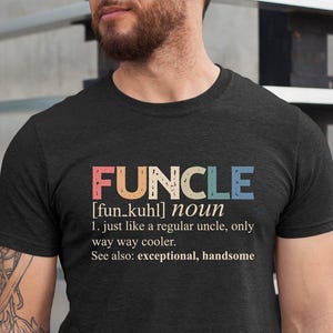 May include: Dark gray t-shirt with the word "FUNCLE" in colorful letters. The shirt defines "FUNCLE" as a cooler version of a regular uncle. The text also includes the words "exceptional" and "handsome".