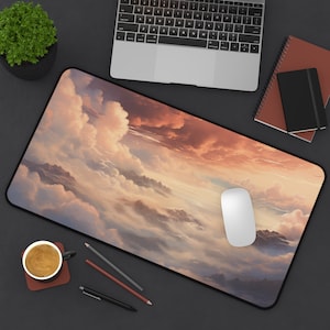 May include: A large mouse mat featuring a scenic image of fluffy clouds and a sunset sky. The mouse mat is black with a stitched edge.