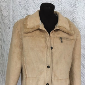 May include: A tan suede jacket with a faux fur collar and cuffs. The jacket has a button front closure and a zippered pocket on the chest.