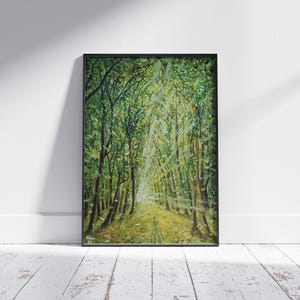 May include: Framed artwork depicting a forest scene with sunlight streaming through the trees. The painting features a path leading into the distance, surrounded by lush green foliage and tall trees. The artwork is in a black frame.