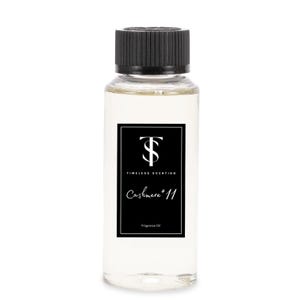 May include: A clear glass bottle with a black cap and a black label. The label has a white logo and the text "Timeless Scenting Cashmere #11 Fragrance Oil".