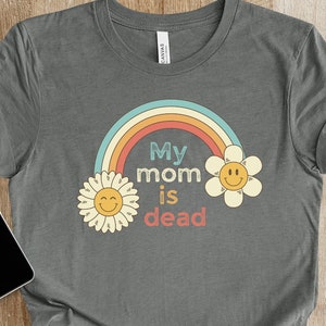 May include: A gray t-shirt with a rainbow and two yellow flowers with smiley faces. The text on the shirt reads "My mom is dead."