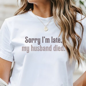 May include: White t-shirt with the text "Sorry I'm late, my husband died."
