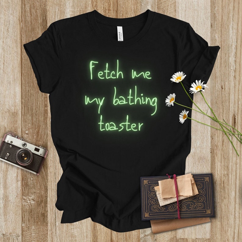 May include: Black t-shirt with the text "Fetch me my bathing toaster" written in green neon.