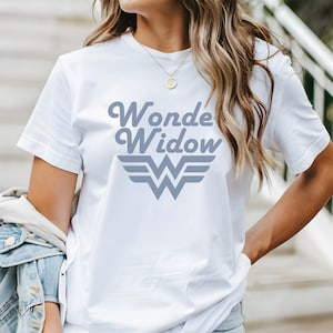 May include: White t-shirt with a gray graphic that says "Wonde Widow" with a stylized Wonder Woman logo.