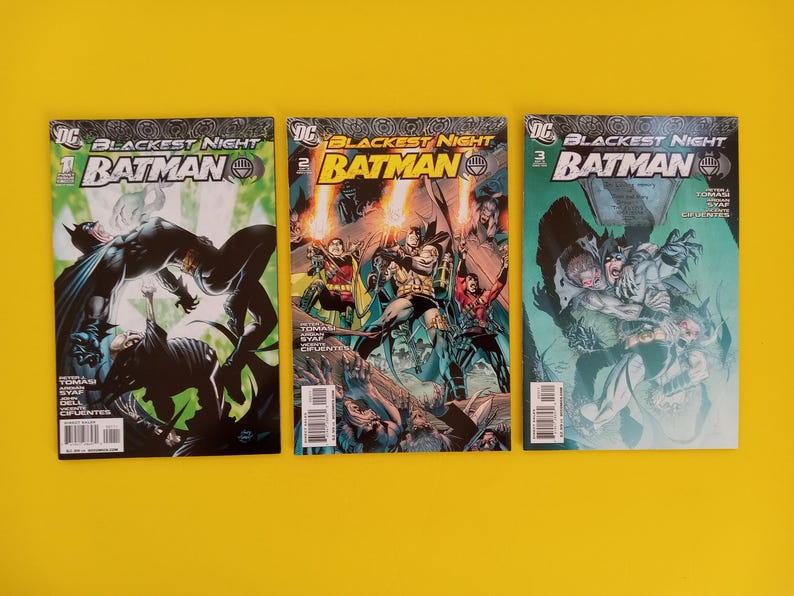 以下が含まれることがあります： バットマンのコミック3冊。「Blackest Night」シリーズで、表紙にはバットマンが描かれています。鮮やかな色使いとダイナミックなイラストが特徴です。背景は黄色です。