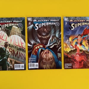 以下が含まれることがあります： 「Blackest Night」シリーズのスーパーマンのコミック3冊。鮮やかなイラストとスーパーマンのロゴが特徴です。表紙には、鮮やかな色とダイナミックなキャラクターのポーズで描かれたアクションシーンが、黄色の背景に描かれています。