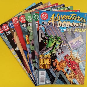 Peut inclure: Une collection de bandes dessinées DC intitulée Adventures in the DC Universe, disposée en éventail pour montrer plusieurs numéros dont les 2, 4, 6, 8, 10, 13 et 14. Le numéro du dessus montre Flash, une équipe de déminage et le texte Battling the Bomb Squad.