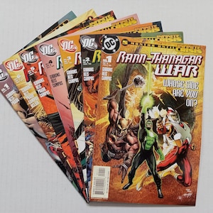May include: A selection of DC Comics comic books, featuring colourful covers with action illustrations. The comics display various issues, including the "Rann-Thanagar War" series, with bold lettering and dynamic character poses.