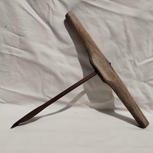 May include: A vintage wooden hand drill with a metal drill bit. The drill is made of weathered wood and has a long handle.