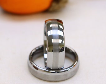 May include: Two silver wedding bands with a beveled edge. The band on top has a polished silver stripe down the center.