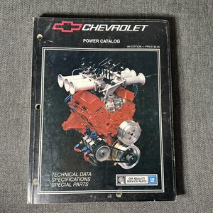 May include: A black Chevrolet Power Catalog, 6th Edition, featuring a red engine illustration. The cover includes the Chevrolet logo, technical data, specifications, and special parts information.