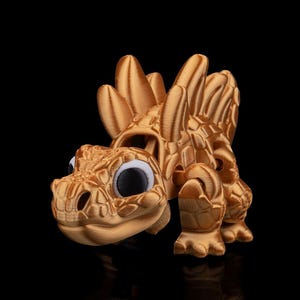 May include: A white ceramic mug with a black handle and the text "But First, Coffee" in a bold, black font. The mug is set against a blurred background, suggesting a cosy setting.