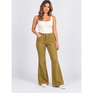 May include: A white sleeveless tank top with a square neckline paired with olive green corduroy flare pants. The pants feature a high-waisted fit, a button and zipper fly closure, and two large patch pockets on the front hips with a wide leg cut.
