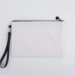 May include: A white canvas zippered pouch with a black zipper and a black strap.