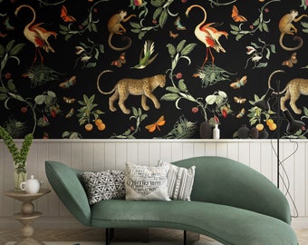 May include: A green curved sofa with three pillows, two with black and white geometric patterns and one with white text on a black background. The sofa is in front of a black wall with a repeating pattern of jungle animals, birds, and butterflies.