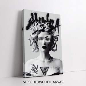 May include: Black and white illustration of Medusa with a snake head and a tattoo on her chest. The word "AURA" is spray painted on the wall behind her.