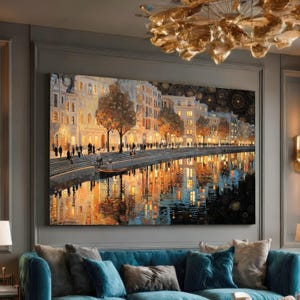May include: A large canvas print depicts a nighttime cityscape with buildings lining a waterway. The artwork features warm, golden hues from streetlights and building interiors, reflected in the water. Silhouettes of people are visible.
