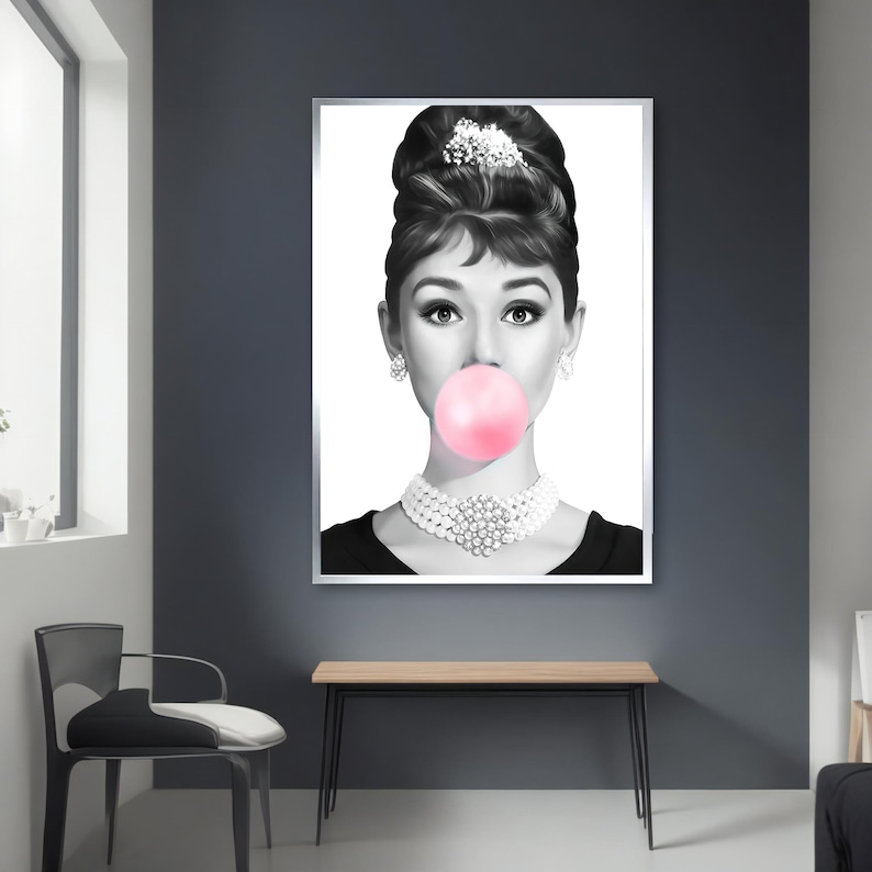 May include: Black and white portrait of a woman with a large pink bubble gum in her mouth. She is wearing a pearl necklace and a black dress.
