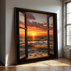 Op de afbeelding: Een groot ingelijst kunstwerk dat een zonsondergang boven de oceaan toont, gezien door een open raam. De lucht is oranje en rood, weerspiegeld in het water. De raamkozijn is donkerbruin en het kunstwerk staat tegen een witte muur.