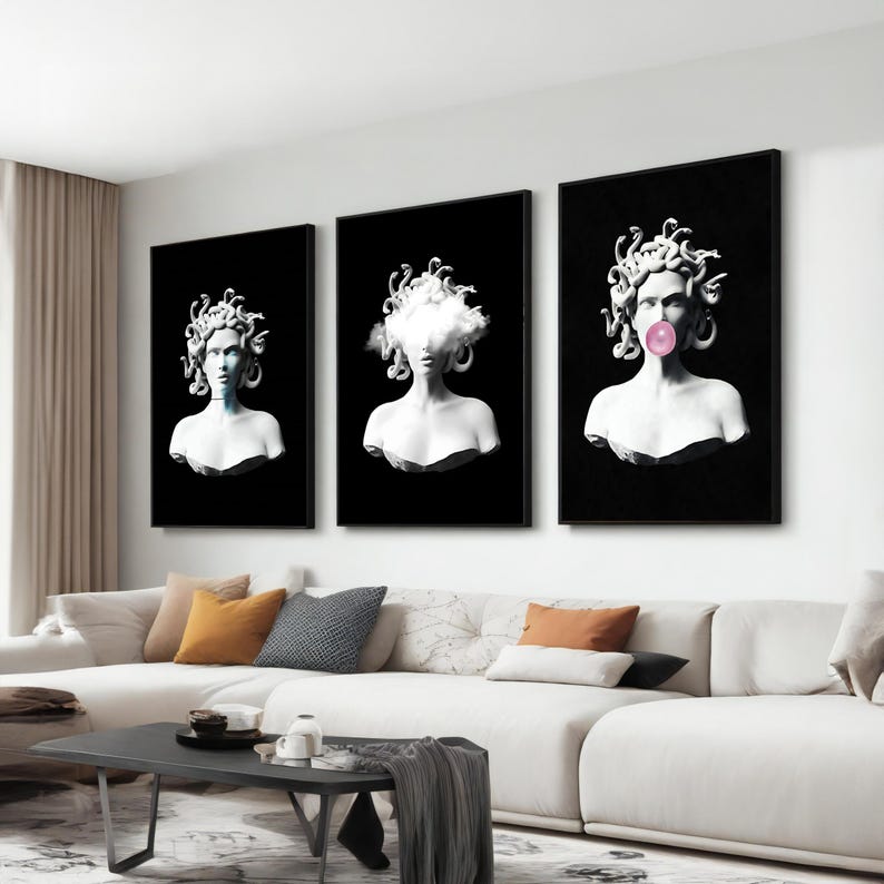 May include: Three framed art prints featuring white busts of Medusa against a black background. One has a cloud, another a bubblegum bubble, and the third has a blue hue. The art is displayed above a white sofa.