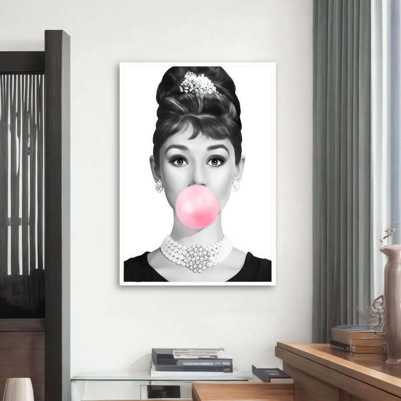 May include: Black and white portrait of a woman with a large pink bubble gum in her mouth. She is wearing a pearl necklace and has her hair styled in a bouffant.