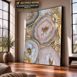 May include: A large rectangular wall art piece featuring an abstract agate stone pattern with concentric layers in shades of beige, grey, and white, accented by textured gold leaf detailing and crystalline clusters throughout the composition.