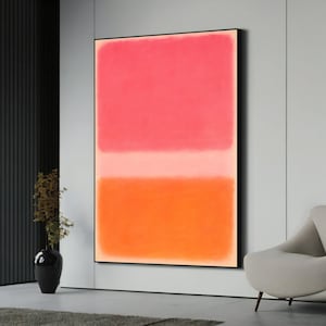 Könnte beinhalten: Großformatiges, gerahmtes abstraktes Gemälde. Das Kunstwerk zeigt einen Farbverlauf: Korallenrosa oben, ein helles Pfirsichband in der Mitte und leuchtendes Orange unten. Das Kunstwerk wird in einem modernen Wohnraum gezeigt.