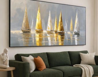 May include: An oil painting depicts a fleet of sailboats with golden sails on a calm sea. The artwork, framed in black, features a muted color palette of gray, gold, and white, creating a serene coastal scene. The painting hangs above a green sofa.