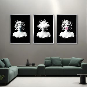 May include: Three framed art prints featuring white busts of Medusa against a black background. One has a blue hue, another has a cloud, and the third has a pink bubble. The prints are displayed above a green sofa.