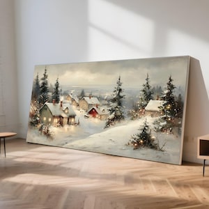 Może przedstawiać: Duży, prostokątny wydruk na płótnie przedstawiający zimową scenerię wioski. Grafika przedstawia pokryte śniegiem domy z podświetlonymi oknami, osadzone wśród wiecznie zielonych drzew. Paleta kolorów jest stonowana z miękkimi bielami, szarościami i odcieniami czerwieni.