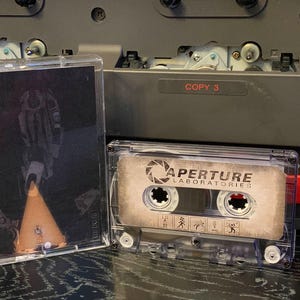 Canciones de Portal 2 para probar, volumen 1 (2011), arte de fan art personalizado en casete para la banda sonora