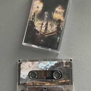 May include: Two clear cassette tapes with artwork. One tape is in its case, the other is loose. The artwork features figures in a landscape with a dark, cavernous background. The tapes have a vintage aesthetic.
